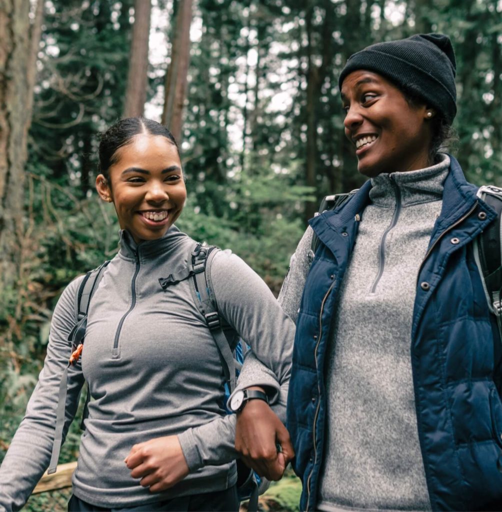 Two women hiking arm in arm